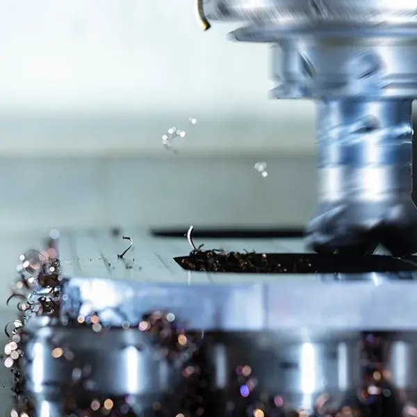 Nahaufnahme eines rotierenden Fräskopfs an einer CNC-Fräsmaschine, der ein Werkstück bearbeitet.