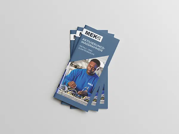 Stapel von drei gefächerten DIN Lang Flyern zum Aktivierungs- und Vermittlungsgutschein (AVGS) auf grauem Hintergrund.