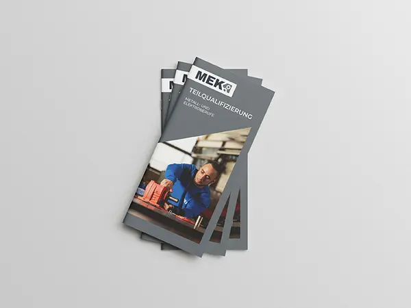 Stapel von drei gefächerten DIN Lang Flyern zur Teilqualifizierung auf grauem Hintergrund.