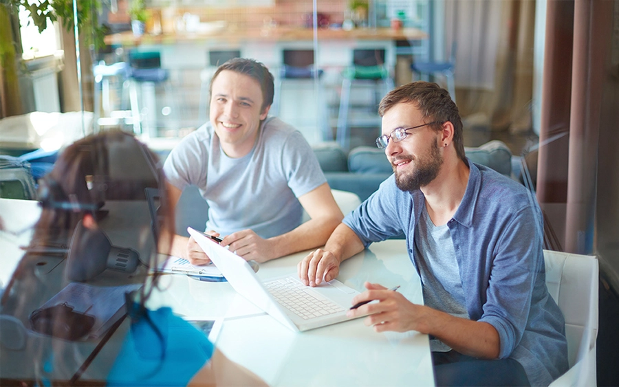 Drei Personen in einem Büro besprechen gemeinsam verschiedene Weiterbildungsmöglichkeiten.