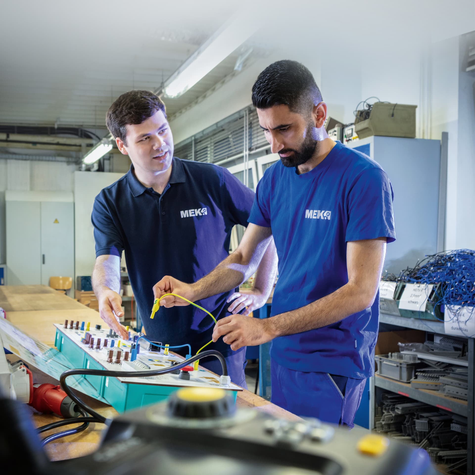 Ausbilder und Umschüler bei einer praktischen Übung in den Werkstätten der MEK